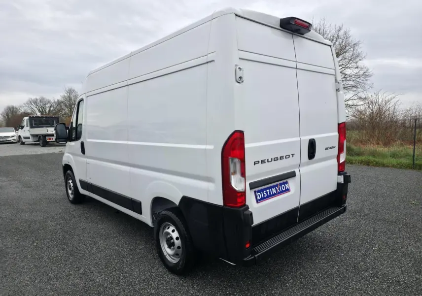 Vue 3/4 arrière droite du Peugeot Boxer Fourgon blanc, avec portes arrière fermées et jantes acier visibles.
