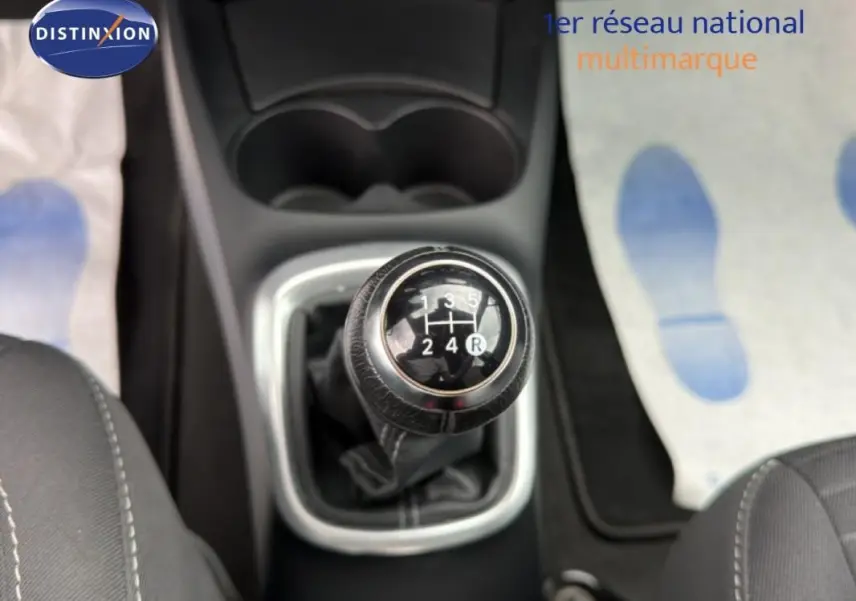 Gros plan sur le levier de vitesse manuel noir au centre de la console d'une Toyota Yaris bleu foncé de 2018.