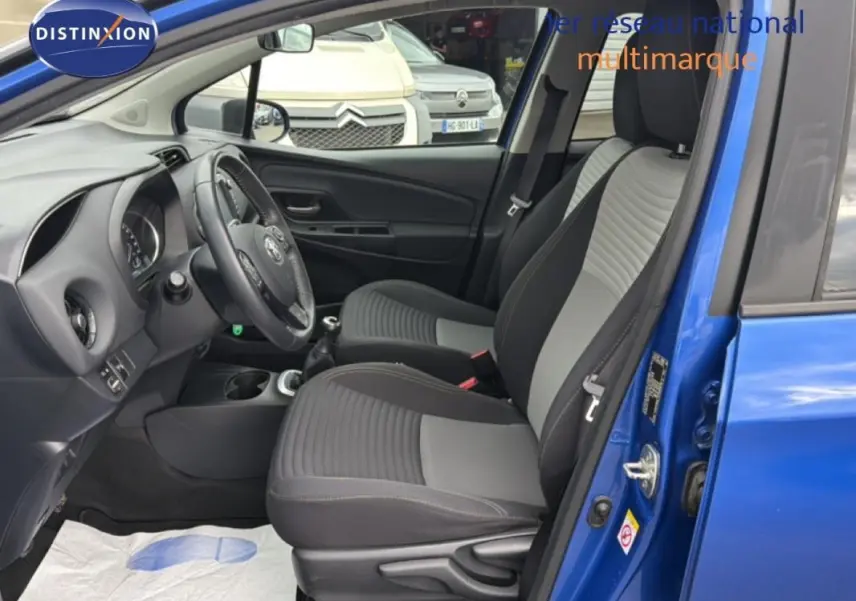 Intérieur de la Toyota Yaris MC2 bleu foncé vu côté conducteur, avec sièges tissu bicolore et volant multifonctions.