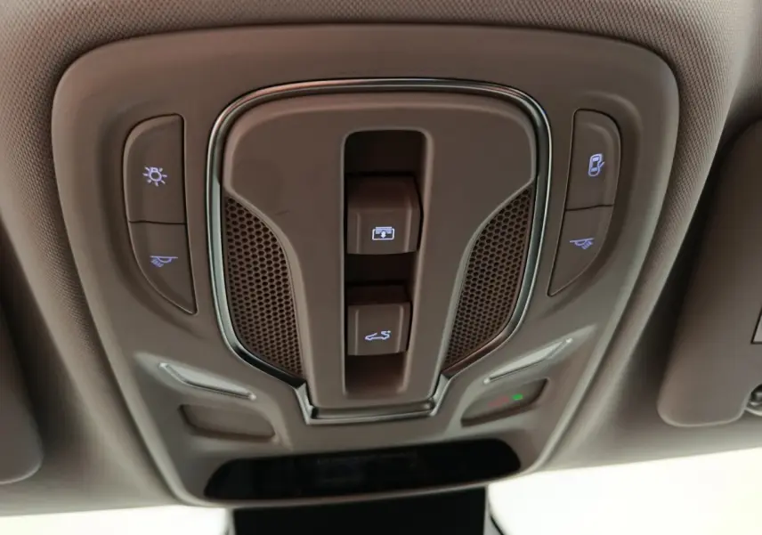 Vue en plongée sur le panneau de commandes de toit intérieur beige du MG Motor ZS Luxury 2024 avec éclairages et ouverture toit.