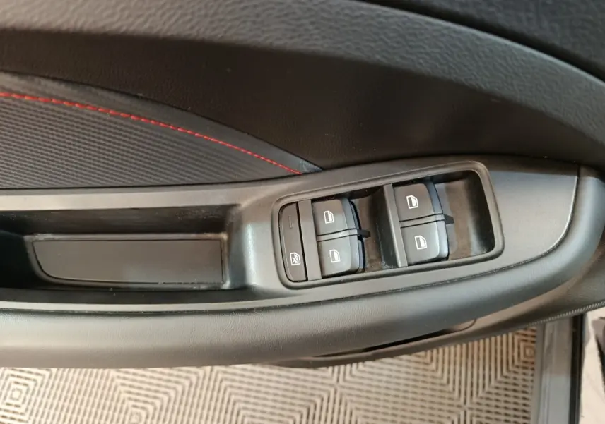 Vue rapprochée des commandes de lève-vitres sur la porte côté gauche d’un MG Motor ZS noir 2024.