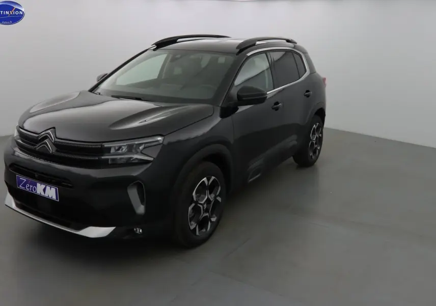 Citroën C5 Aircross noir perle vu en 3/4 avant droit, avec jantes bi-ton et barres de toit noires.