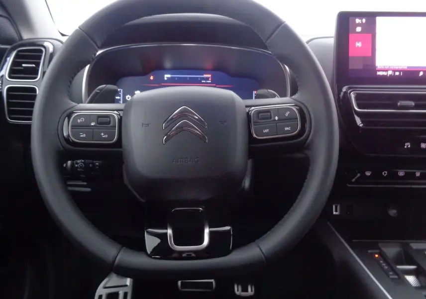 Vue centrée sur le volant noir du Citroën C5 Aircross 2022 avec commandes intégrées et tableau de bord numérique.