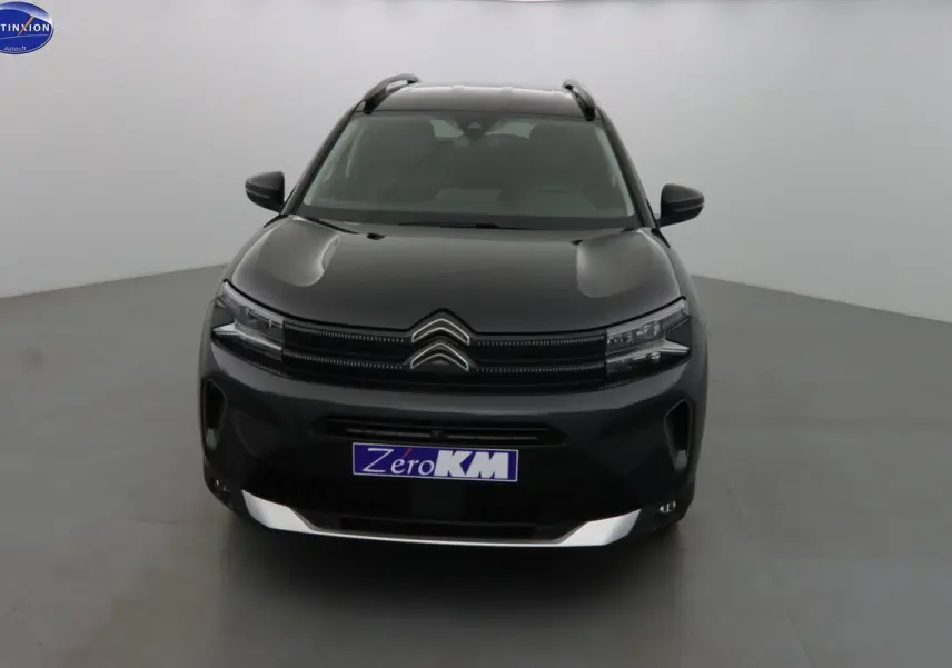 Vue frontale d'un Citroën C5 Aircross noir perle avec calandre distinctive et barres de toit visibles.
