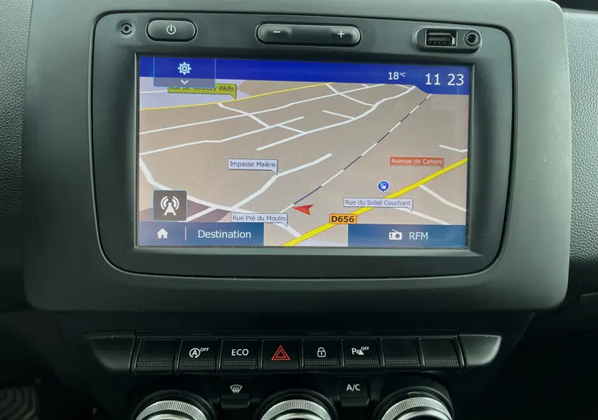 Écran tactile GPS du tableau de bord du Dacia Duster bleu marine 2018, avec commandes climatisation et mode ECO visibles.