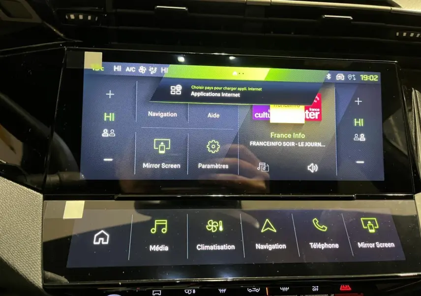 Vue intérieure du tableau de bord tactile de la Peugeot 308 GT 2024 avec écran multimédia et commandes climatisation.