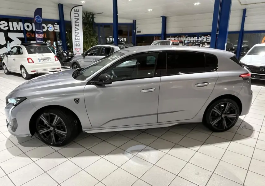 Profil côté gauche d'une Peugeot 308 GT gris Artense avec jantes alliage 18'' Kamakura en showroom.