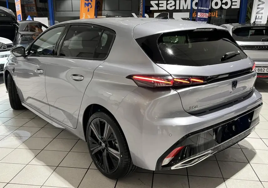 Vue 3/4 arrière droite d'une Peugeot 308 GT gris Artense avec feux arrière LED et jantes alliage 18 pouces.