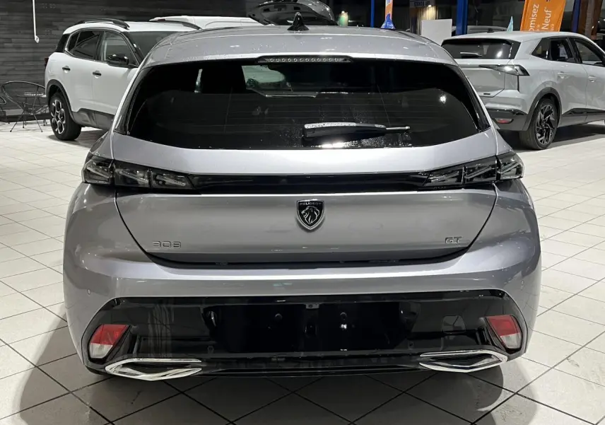 Vue arrière d'une Peugeot 308 GT gris Artense avec feux arrière en bandeau noir brillant et double sortie d'échappement chromée.