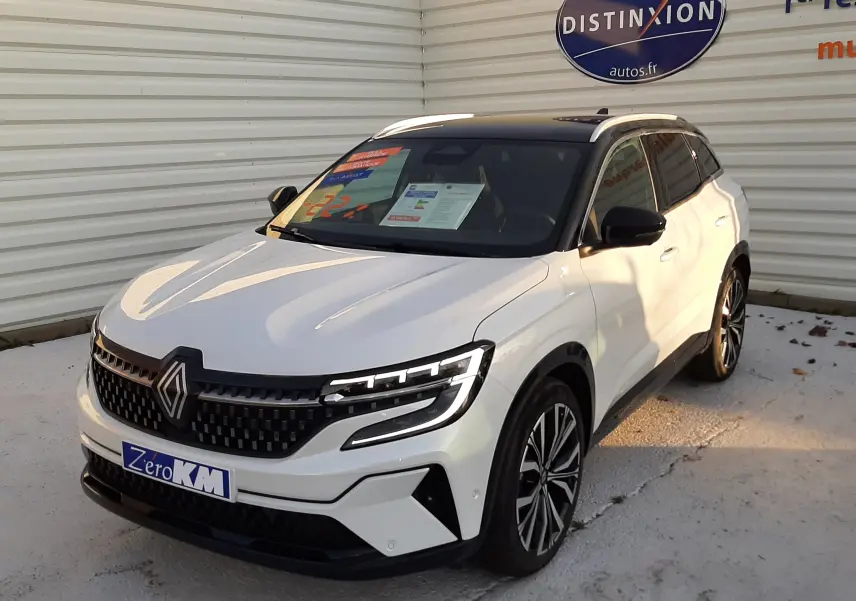 Renault Austral E-Tech Full Hybrid 200 Iconic blanc nacré avec toit noir, vue 3/4 avant sur sol mouillé