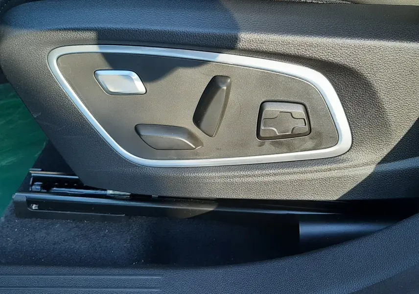 Commandes électriques de réglage du siège conducteur en cuir noir dans un Renault Austral E-Tech 2025 blanc nacré.