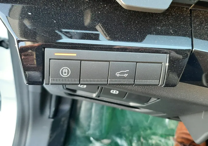 Gros plan sur les boutons de commande noirs du tableau de bord d'un Renault Austral blanc nacré avec toit noir.