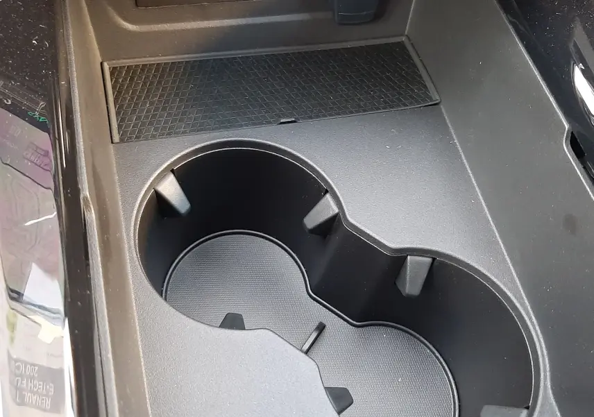 Gros plan sur la console centrale noire du Renault Austral 2025, avec porte-gobelets et ports USB visibles.