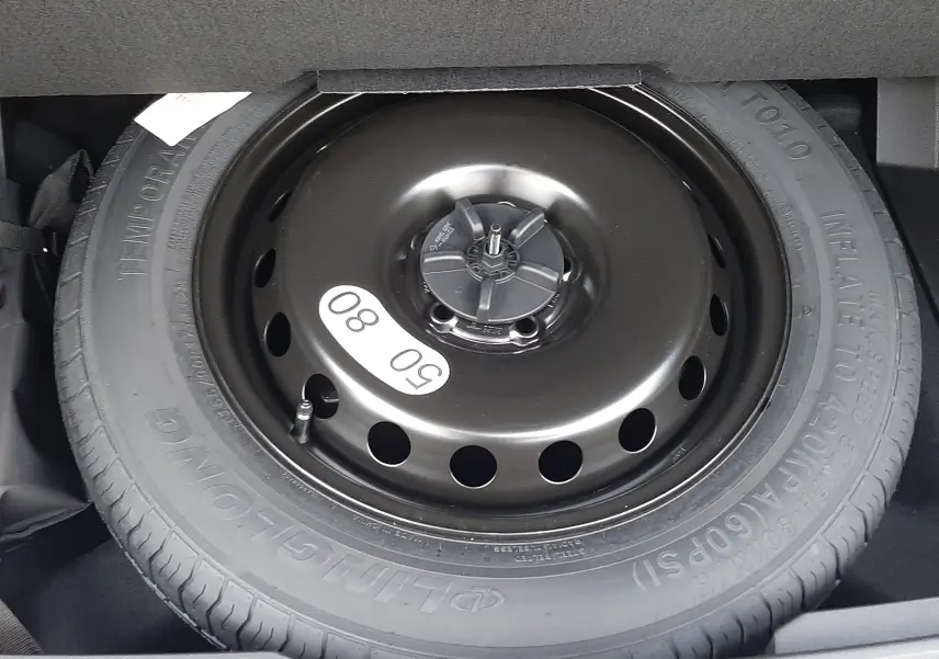 Roue de secours provisoire noire en gros plan dans le coffre du Renault Austral 2025 blanc nacré toit noir.