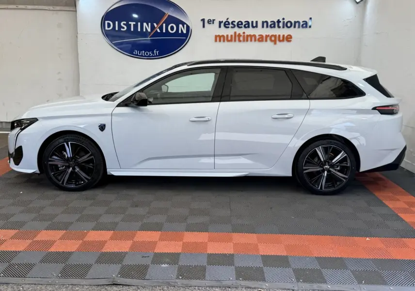 Peugeot 308 Hybrid 136 e-DCS6 GT blanc vue de profil côté gauche avec jantes noires et toit ouvrant.