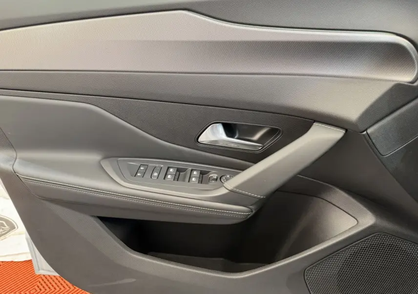 Vue rapprochée de la porte avant gauche intérieure noire de la Peugeot 308 Hybrid 136 e-DCS6 GT 2024.