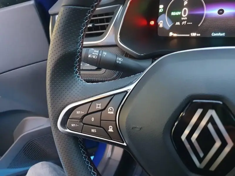 Gros plan sur le volant cuir multifonction et le tableau de bord numérique du Renault Captur Bleu Iron 2025.