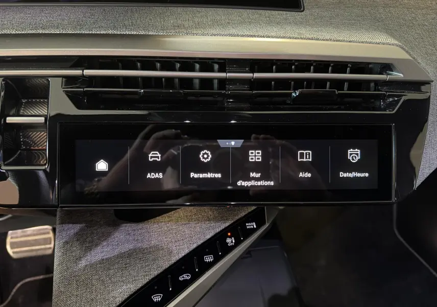Vue rapprochée de l’écran tactile central et de la console du Peugeot 5008 Hybrid 145 e-DCS6 GT avec finition tissu gris.