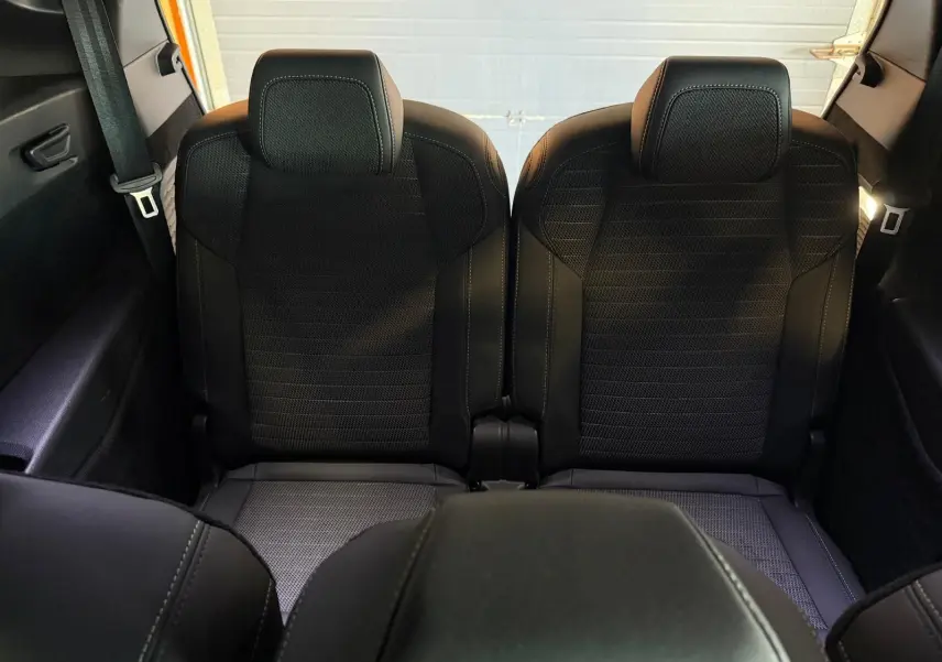 Vue arrière centrée sur les deux sièges noirs du troisième rang du Peugeot 5008 Hybrid 145 GT, avec ceinture visible.