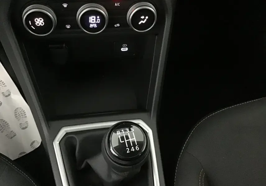 Gros plan sur la console centrale de la Dacia Sandero Stepway 2025, montrant la boîte manuelle et les commandes de climatisation.