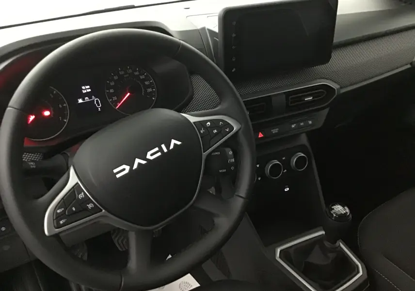 Vue intérieure du tableau de bord et volant Dacia Sandero Stepway 2025, avec console centrale et levier de vitesses manuel.