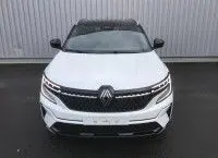 Vue de face du Renault Austral 2025 blanc nacré avec toit noir, mettant en valeur sa calandre distinctive et ses phares LED.