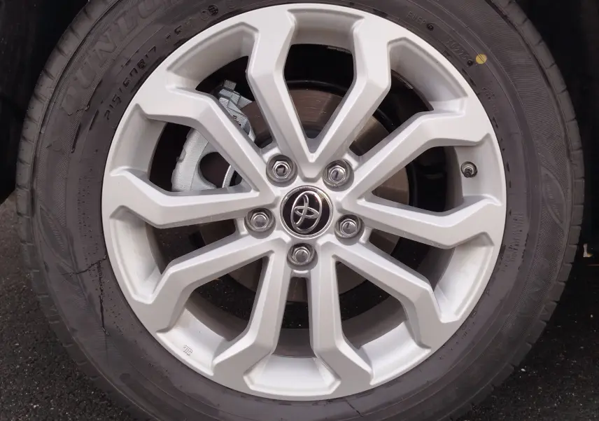 Gros plan sur la jante alliage argentée de la Toyota Corolla Cross 2025, avec logo Toyota au centre et pneu Dunlop.