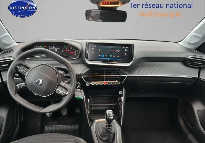 Intérieur de Peugeot 208 2024 vue tableau de bord et volant côté gauche, finition gris artense avec écran tactile central.