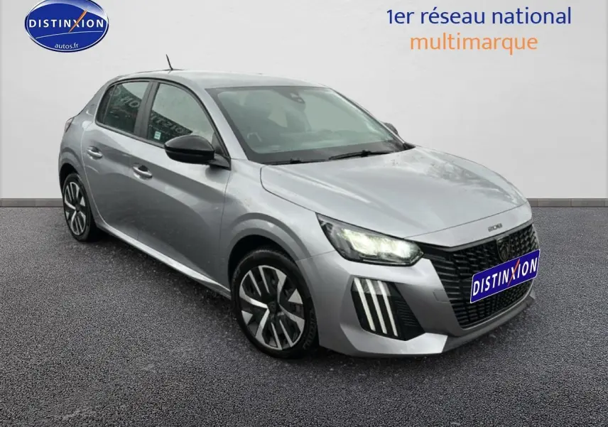 Peugeot 208 gris artense vue 3/4 avant droit avec phares allumés et jantes alliage distinctives.