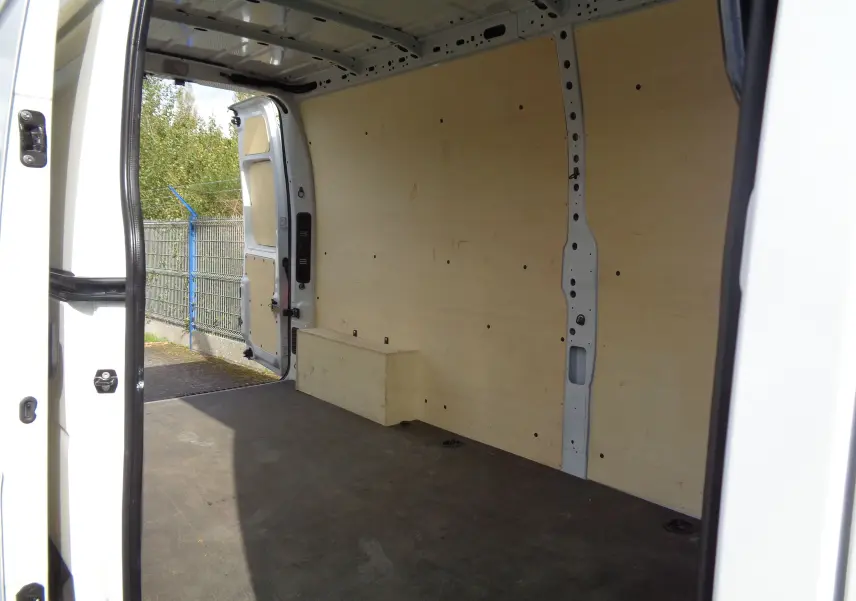 Intérieur du fourgon Opel Movano L3H2 blanc polaire vu de la porte latérale ouverte, montrant la zone de chargement vide.