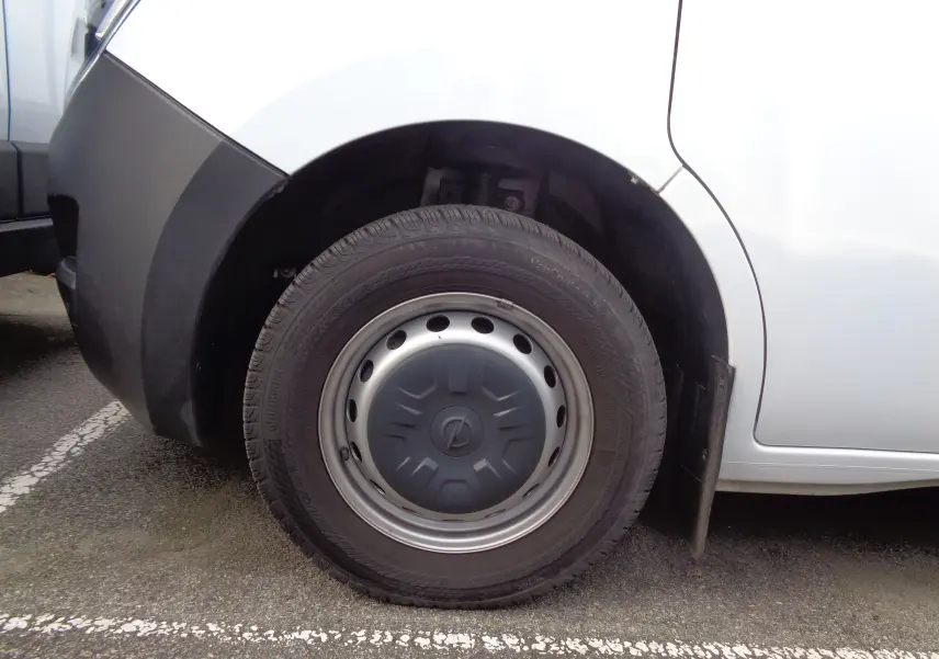 Gros plan sur la roue avant gauche d’un Opel Movano Fourgon blanc polaire avec enjoliveur gris et pare-boue noir.