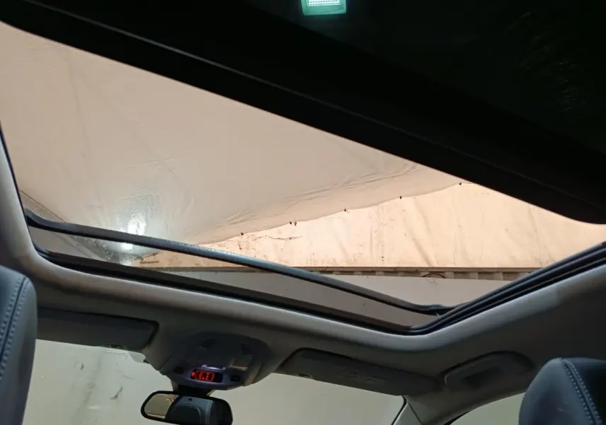 Vue intérieure du toit ouvrant panoramique du Peugeot 3008 blanc, avec ciel partiellement visible à travers le verre.