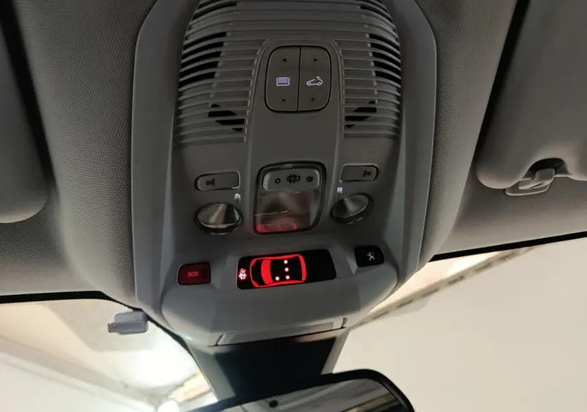 Vue en contre-plongée du plafonnier intérieur gris avec commandes lumineuses et bouton SOS du Peugeot 3008 blanc.