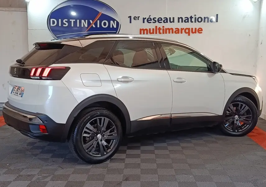 Peugeot 3008 blanc vue de profil côté droit, avec jantes noires et feux arrière LED allumés.