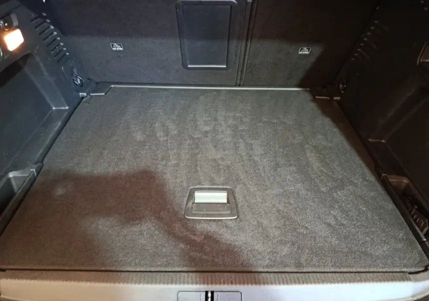 Vue intérieure du coffre spacieux et plat du Peugeot 3008 blanc, version Puretech 130 S&S EAT8 Allure, avec éclairage latéral.