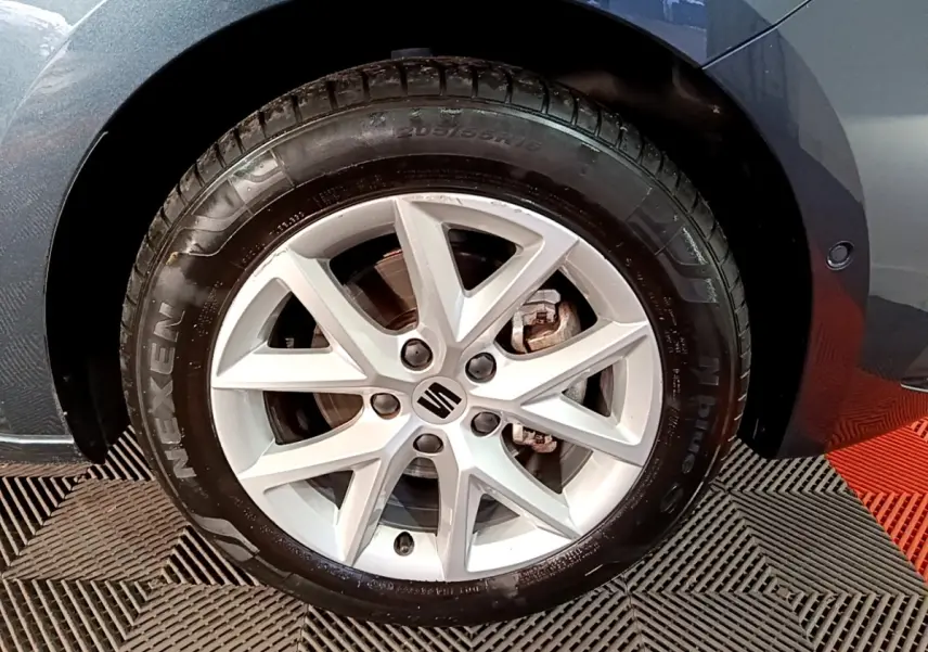 Gros plan sur la roue avant droite gris clair d'une SEAT LEON 2023 avec jante alliage à 5 doubles branches.
