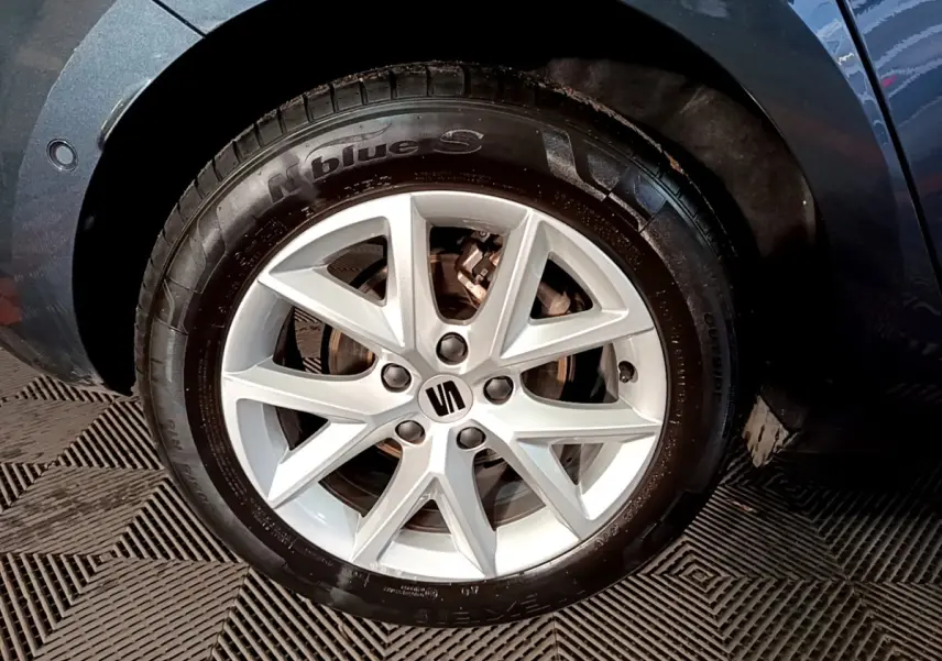 Gros plan sur la roue avant droite gris clair d'une SEAT LEON 2023 avec jante alliage à 5 doubles branches.