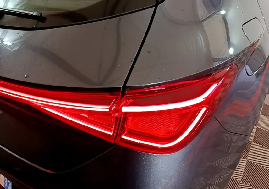 Gros plan sur le feu arrière droit rouge vif d’une SEAT LEON gris clair 2023, soulignant la carrosserie lisse.