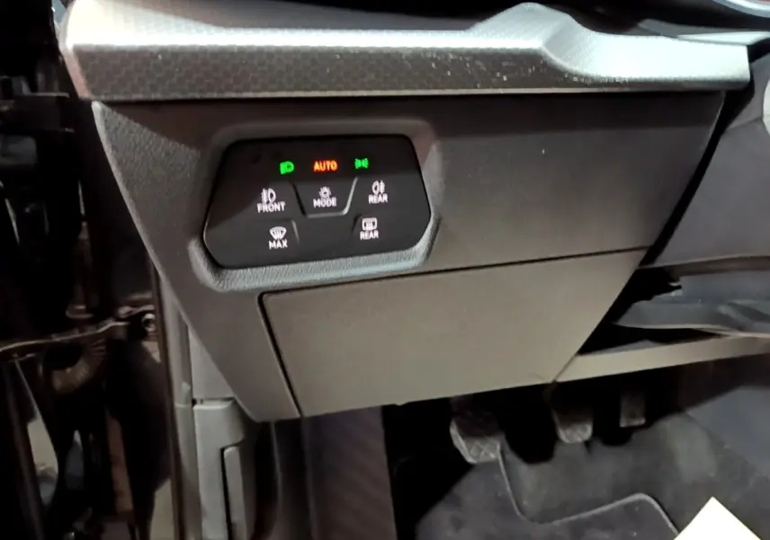 Gros plan sur le tableau de bord côté conducteur du SEAT Leon 2023, montrant les commandes d’éclairage et les pédales noires.