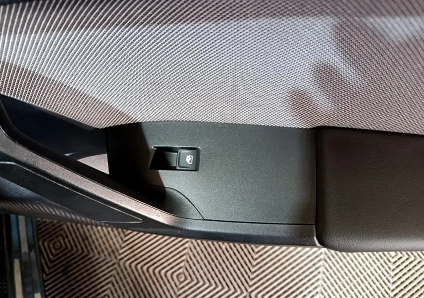 Détail de l’accoudoir intérieur côté gauche du SEAT Leon 2023 avec bouton de verrouillage des portes.