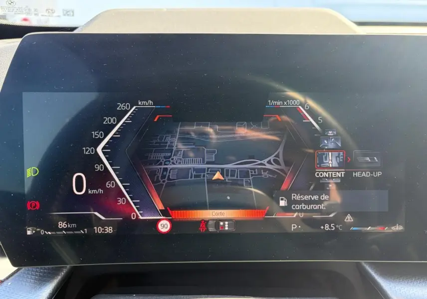 Affichage numérique du combiné d'instrumentation BMW X1 2025 montrant la navigation et alertes, vue de face intérieure.