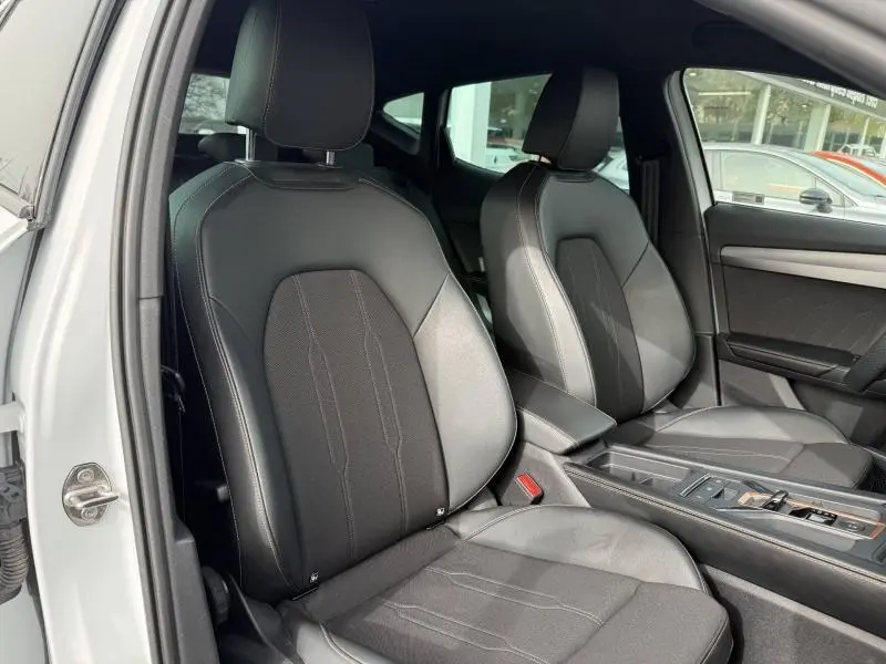 Vue intérieure côté gauche montrant les sièges avant en cuir noir du CUPRA Formentor blanc Nevada 2025.