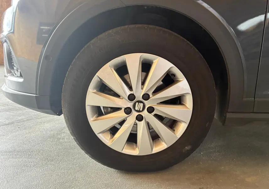 Gros plan sur la roue avant droite d’un SEAT Arona gris foncé, mettant en valeur la jante alliage à rayons fins.