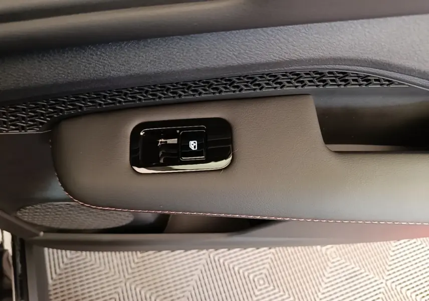 Détail de la commande de lève-vitre sur la porte intérieure noire du Nissan Ariya 63kWh 218ch Engage 2026.