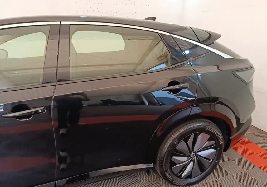 Vue côté droit arrière du Nissan Ariya noir 63kWh 218ch Engage avec jante stylisée et poignées de porte intégrées.