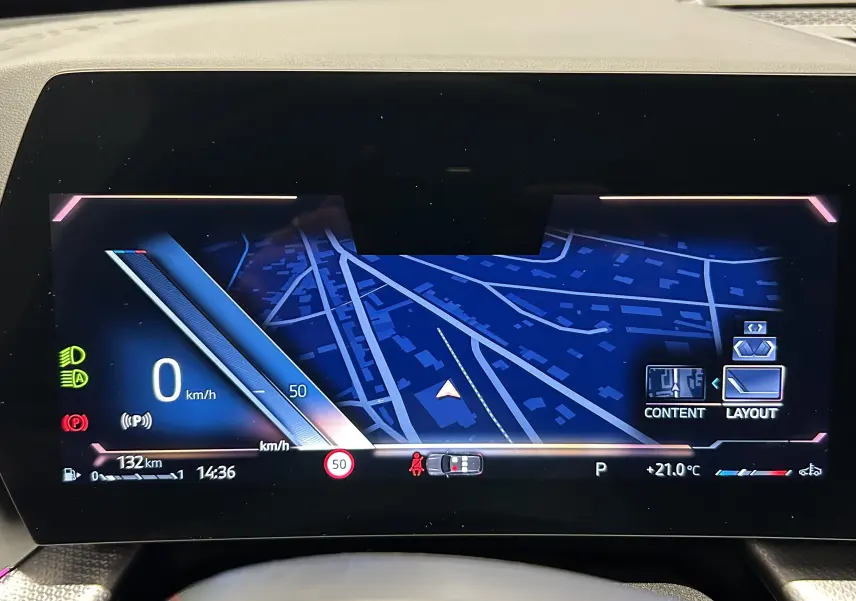 Affichage numérique du tableau de bord du BMW X1 2024, montrant la navigation et les informations de conduite en mode stationnement.