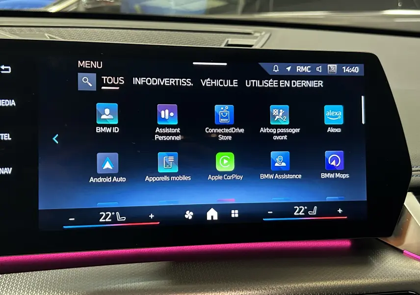 Écran tactile central du BMW X1 2024 affichant les applications connectées avec éclairage d'ambiance rose.