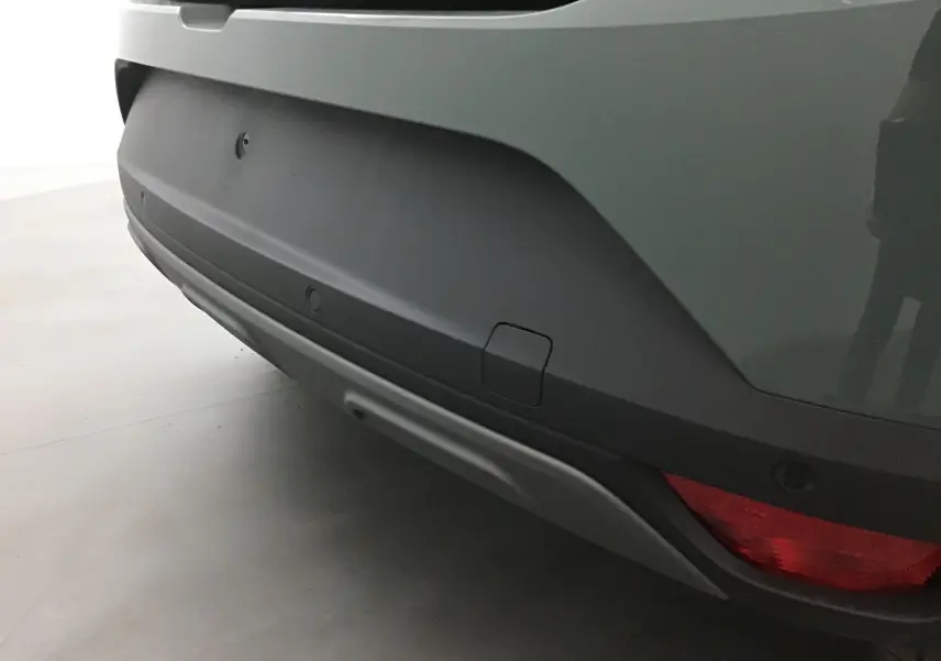 Gros plan sur le pare-chocs arrière kaki du Dacia Sandero Stepway 2025 avec feu rouge et capteurs de recul intégrés.