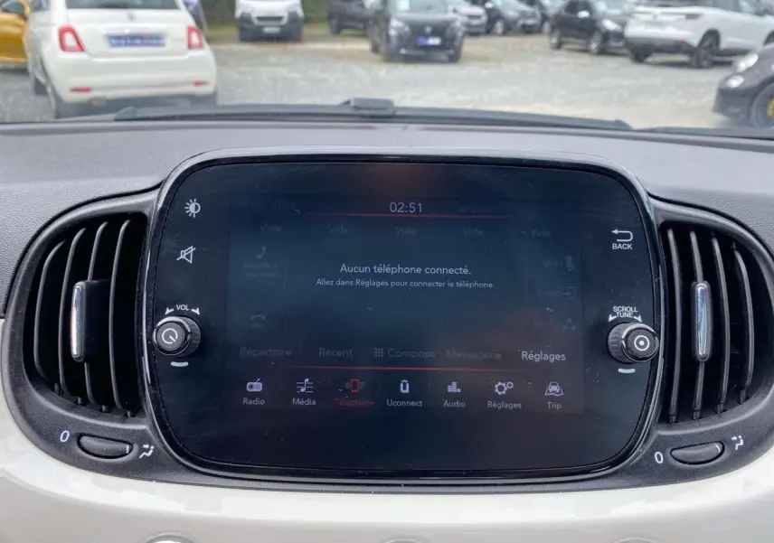 Écran tactile central du tableau de bord d'une Fiat 500 blanche 2024, avec commandes multimédia et ventilation visibles.