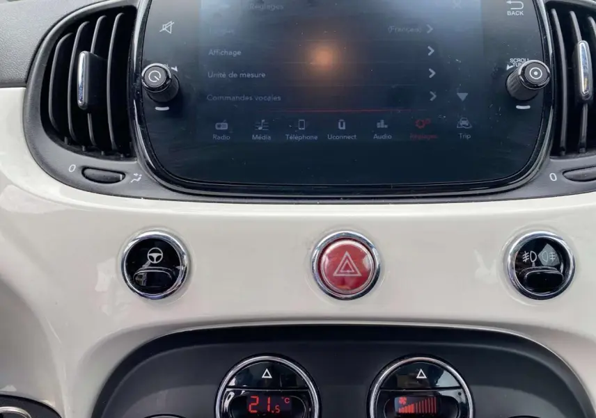 Tableau de bord blanc de la Fiat 500 2024 avec écran tactile et commandes climatisation affichant 21,5°C.